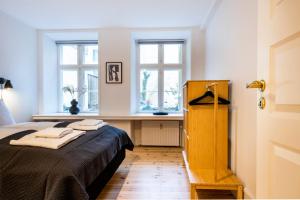 a bedroom with a bed with a desk and two windows at Town Hall Apartments by Daniel&Jacob's in Copenhagen
