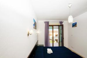 a bedroom with a blue bed and a window at I Girasoli in Bari Sardo +91 photos