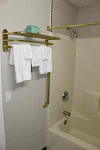 a bathroom with a shower and white towels at Liberty Inn Absecon Atlantic City in Galloway +40 photos