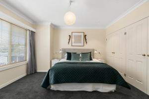 a bedroom with a large bed with a green bedspread at SEA BREEZE on THE CRESCENT in Inverloch