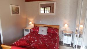 a bedroom with a bed with a red blanket at The Petite Chalet Chambre d'hôtes in LʼIsle-Jourdain