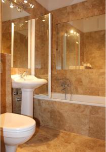 a bathroom with a sink and a toilet and a tub at Cracow Apartments 24 in Krakow