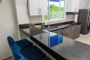 a kitchen with a counter with blue chairs in it at VILLA MANDALAY in Santa Veronica