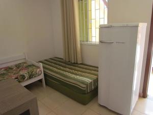 Habitación pequeña con nevera y cama en Moradas Dias, en Florianópolis