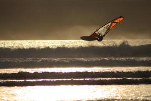 a kite is flying over the waves on the beach at L'Imprenable vue mer in Crozon