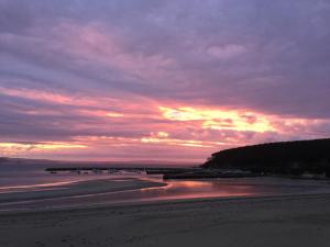 a sunset on a beach with a cloudy sky at L'Imprenable vue mer in Crozon