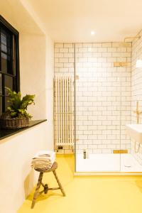 a bathroom with a shower with a stool in it at The Bull Inn in Totnes