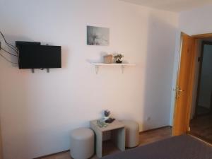 a living room with a tv and a table at Apartment and Rooms Nevenka in Poljanak