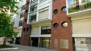 a brick building with round windows on the side of it at Luminoso Ambiente, con cochera en lo mejor de La Perla in Mar del Plata