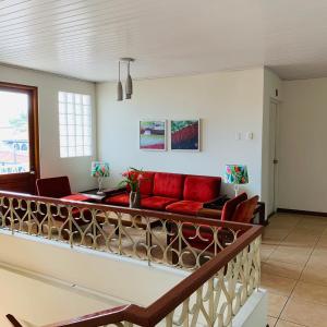 a living room with a red couch on a balcony at Hotel Acosta in Iquitos