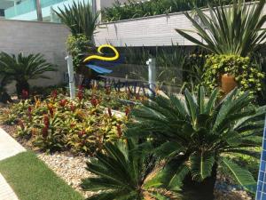 un jardín con un montón de plantas y árboles en Duplex lindo sofisticado, en Governador Celso Ramos
