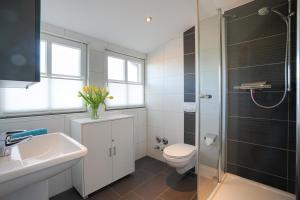 a bathroom with a toilet and a sink and a shower at Leuchtturmhaus 1888 in Borkum +7 photos