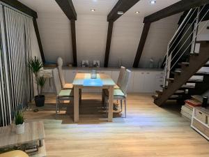 a dining room with a wooden table and chairs at Gemütliches Ferienhaus in ruhiger Lage Ronshausen Hessen in Ronshausen