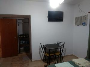a room with a table and chairs and a tv on the wall at Hotel Las Moras in La Rioja