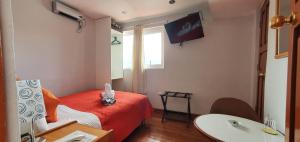 um quarto de hotel com uma cama vermelha e um lavatório em HOTEL AMTALLPA San Blas Inn em Cusco