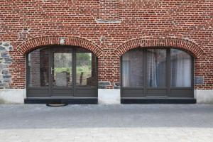 two windows on the side of a brick building at Au Moulin à Paroles in Tournai