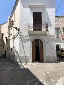 biały budynek z drzwiami i balkonem w obiekcie Gabriele-Apartment w mieście Gallipoli