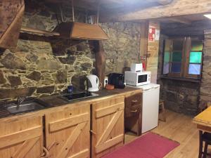 a kitchen with a sink and a stone wall at Casa de Baixo in Lousã