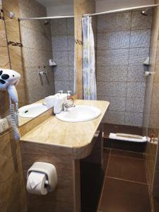 y baño con lavabo y ducha. en HOTEL AMTALLPA San Blas Inn, en Cusco