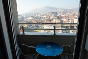 - une table dans une fenêtre avec vue sur la ville dans l'établissement Novi Pazar Apartman lux, à Novi Pazar