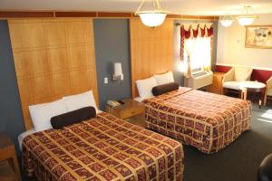 a hotel room with two beds and a chair at Liberty Inn Absecon Atlantic City in Galloway