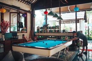 a man playing pool in a room with a child at Godiva Villa Phu Quoc in Phu Quoc