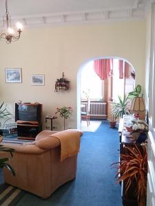a living room with a couch and a tv at Villa Hebel in Cuxhaven