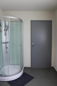 La salle de bains est pourvue d'une douche et d'une porte en verre. dans l'établissement Au Moulin à Paroles, à Tournai