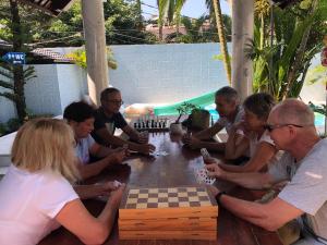 a group of people sitting around a table playing chess at Godiva Villa Phu Quoc in Phú Quốc