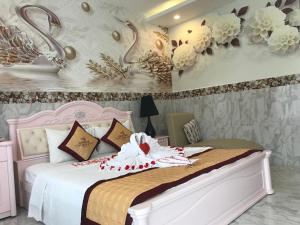 a bedroom with a white bed with flowers on the wall at Godiva Villa Phu Quoc in Phú Quốc