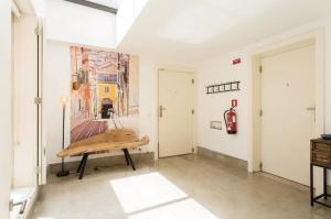 une chambre avec un banc et un tableau sur le mur dans l'établissement Beautiful 3-Story house in Chiado with a 40m² private terrace, à Lisbonne