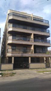 a tall building with a fence in front of it at Cobertura Aconchegante Itaúna in Saquarema