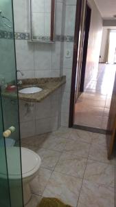 a bathroom with a shower and a toilet and a sink at Cobertura Aconchegante Itaúna in Saquarema
