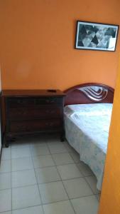 a bedroom with a bed and a dresser and a picture at Cobertura Aconchegante Itaúna in Saquarema