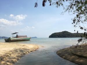 a boat sitting on the shore of a beach at Mr Bao Homestay & Bungalows in Ko Yao Noi