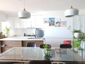 a white kitchen with a glass table and chairs at The Grand Condotel in Vung Tau