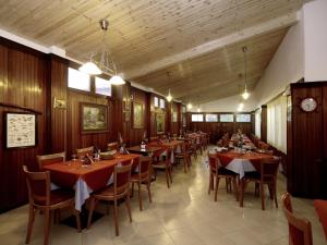 a dining room with tables and chairs and a clock at Hotel Signorini in Castiglioncello