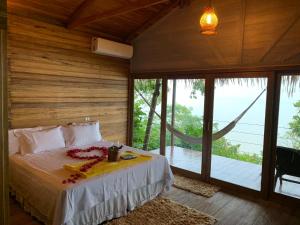 a bedroom with a bed in a room with windows at Alta Vista Amazon Lodge in Manacapuru