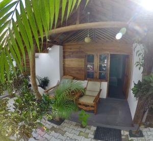 um alpendre de uma casa com uma cadeira e algumas plantas em Garden Beach Hotel em Arugam Bay