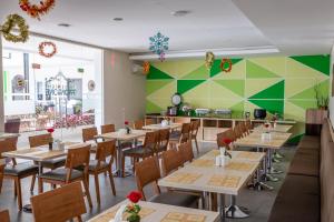 a restaurant with tables and chairs and a green wall at Three Eight Front One Boutique Batu Malang in Batu