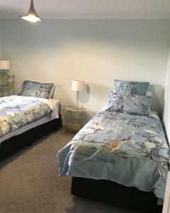 1 dormitorio con 2 camas y lámpara en Werndee en Hobart