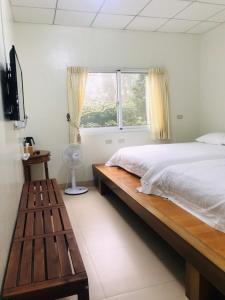Un dormitorio con una cama grande y una ventana en Riley Ming Xuan B&B, en Meishan