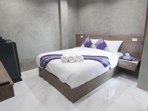a bedroom with a large bed with two towels on it at Puak Taem Boutique Hotel in Chiang Mai