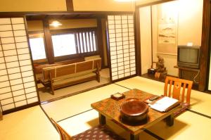 Zimmer mit einem Tisch und einem TV in einem Zimmer in der Unterkunft Yumoto Choza in Takayama