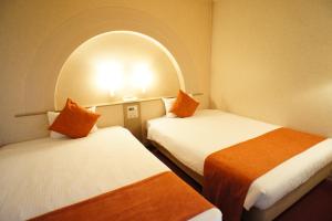 a room with two beds and an arched window at Osaka Joytel Hotel in Osaka