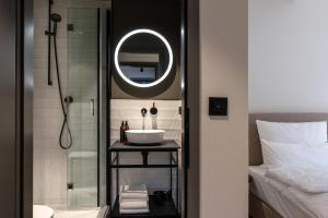 a bathroom with a sink and a mirror at THE ADAMS - Self Check In Hotel in Baden-Baden