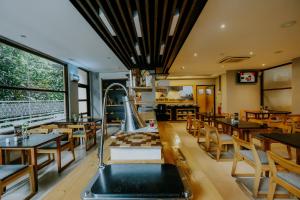 un ristorante con tavoli e sedie in legno e una scacchiera di Ayaartta Hotel Malioboro a Yogyakarta