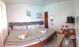 a bedroom with a bed with two rubber ducks on it at WHITE BEACH GUEST HOUSE in Puerto Galera