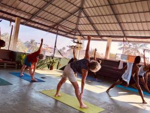 a group of people doing yoga in a tent at Goodkarma Inn in Cochin