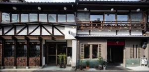京都的住宿－UNKNOWN KYOTO，一座高大的建筑,上面设有一个阳台